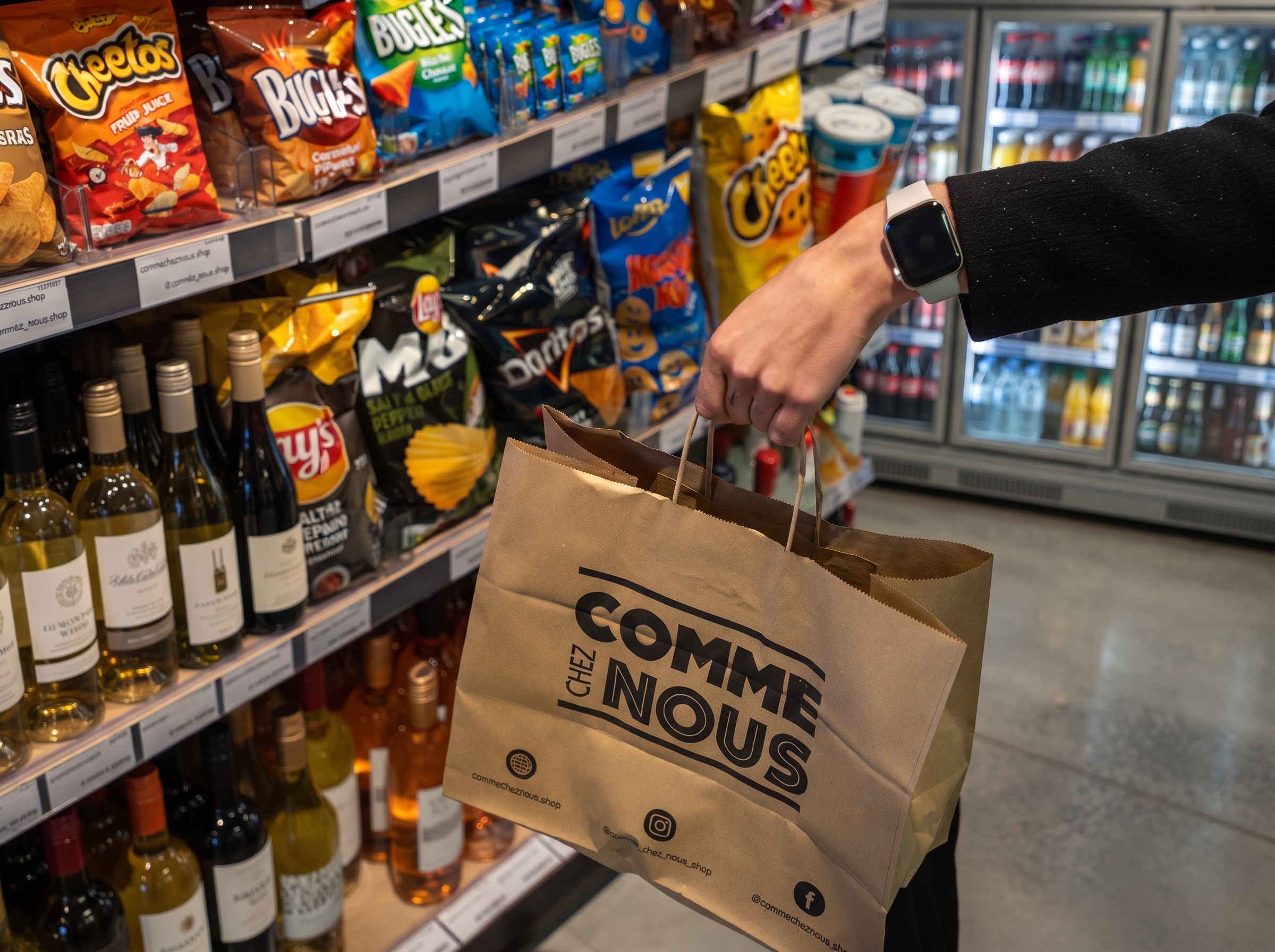 Klant met Comme Chez Nous-afhaalzak voor een gevuld snackrek